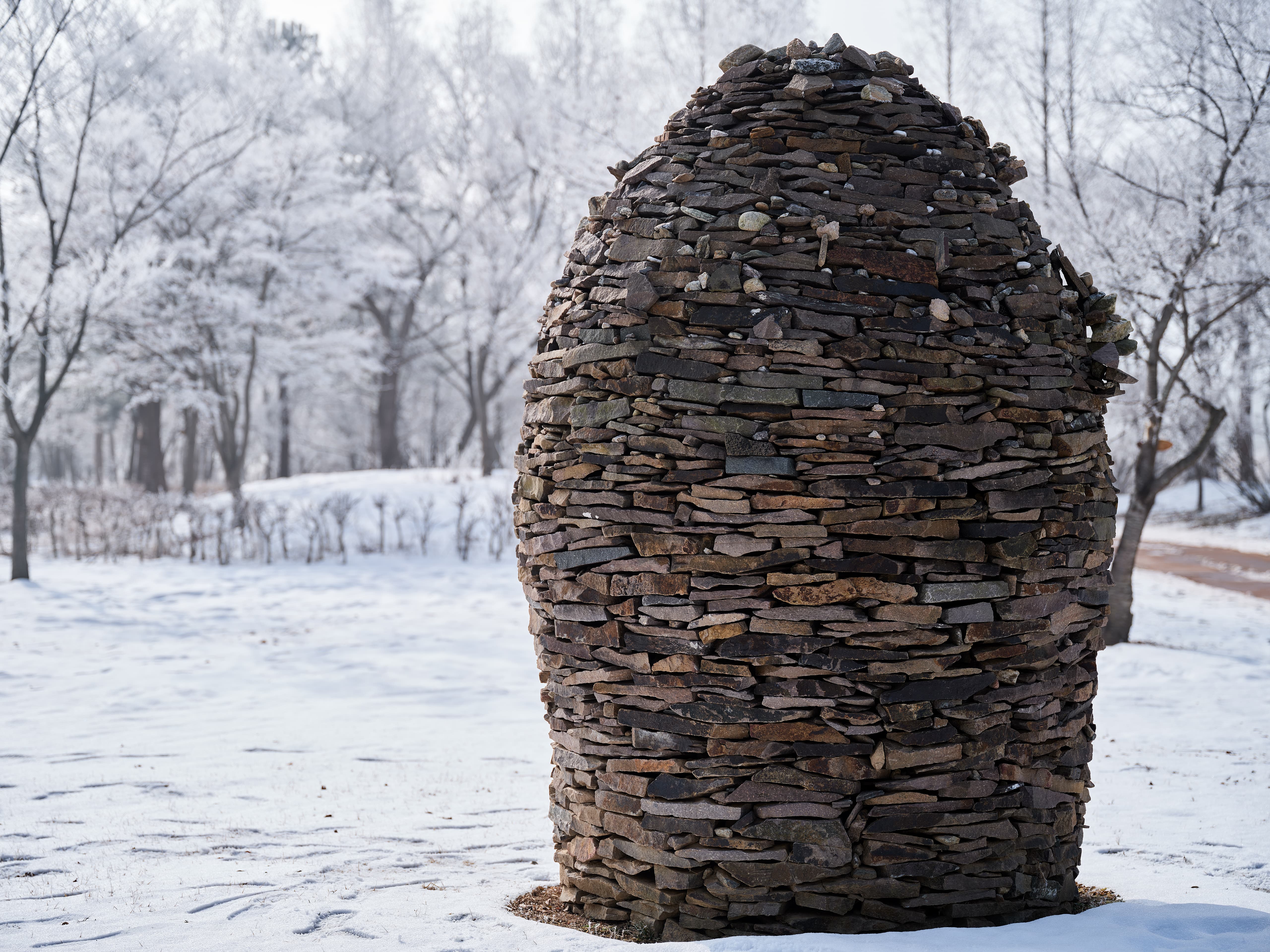 Stone Sculpture Amidst Frosty Landscape