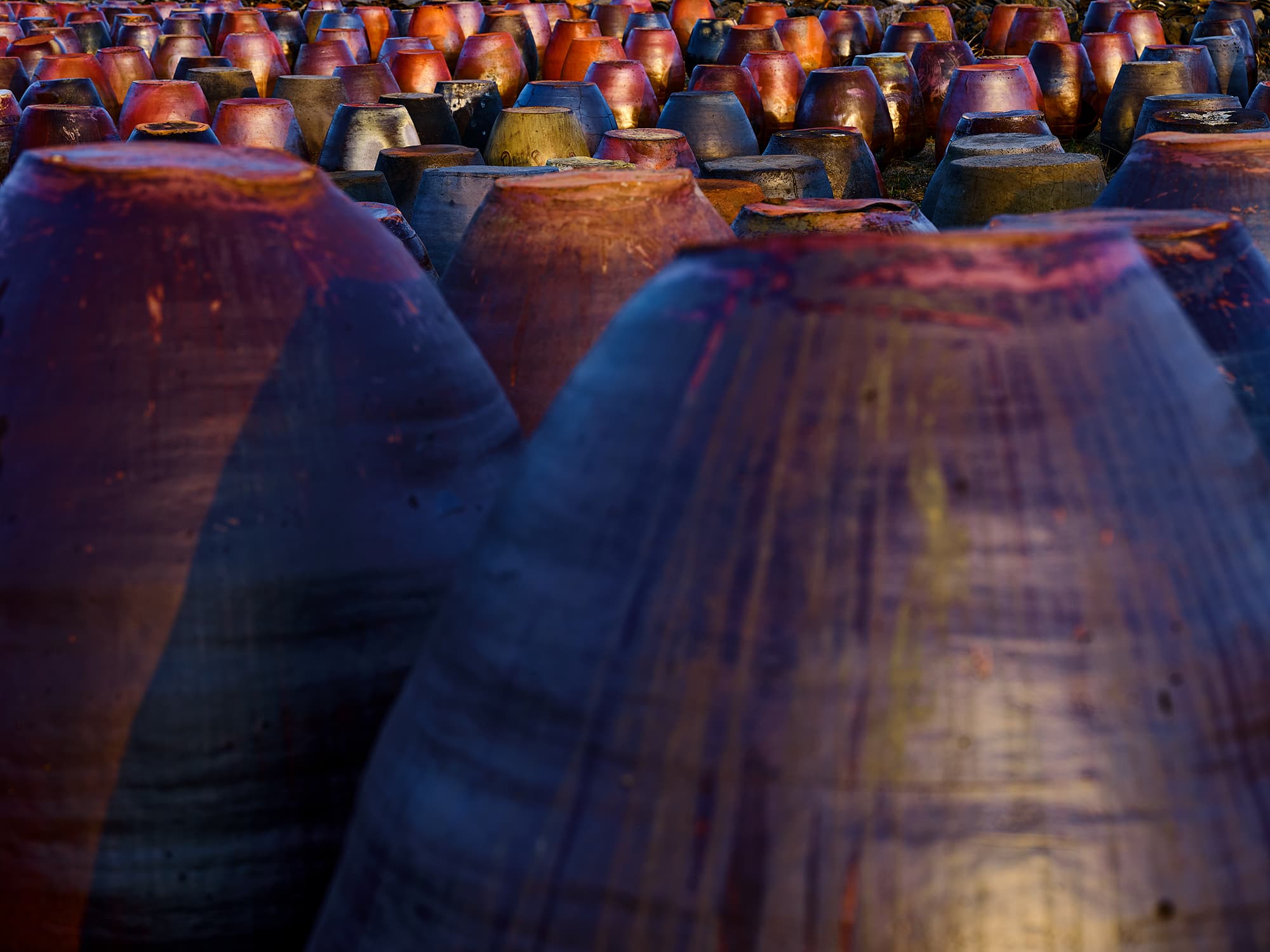 Field of upturned Onggi jars in dramatic blue and orange light
