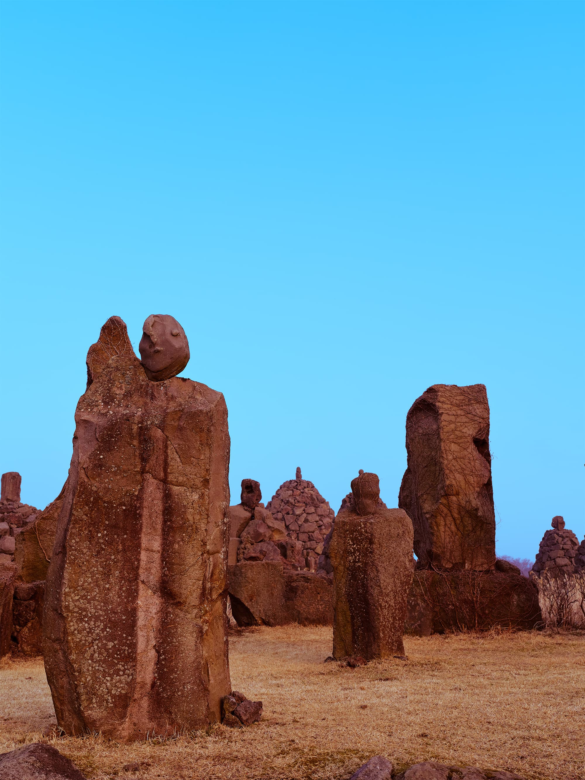 Tall stone sculptures of the Five Hundred Generals against a vivid blue sky